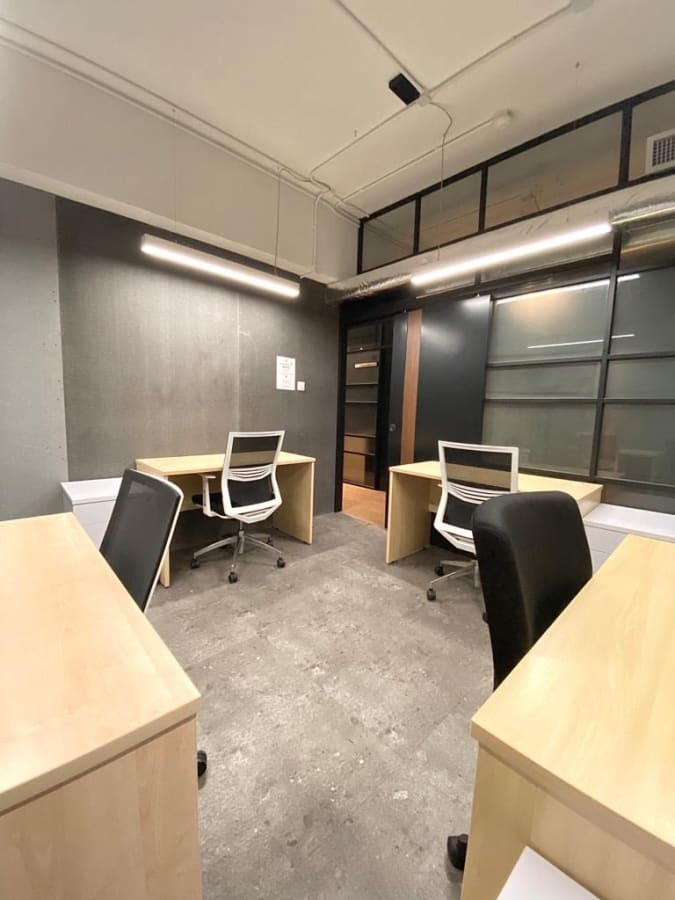 Modern coworking space with ample natural light, ergonomic chairs, and sleek desks.