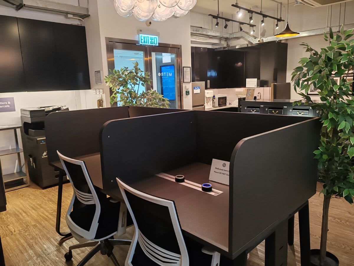 Flexible coworking space with private work pods, modern lighting, and a cozy atmosphere.