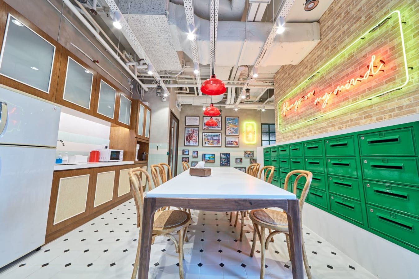 Vibrant coworking space with modern kitchen, ample seating, and artistic decor. Ideal for collaboration.