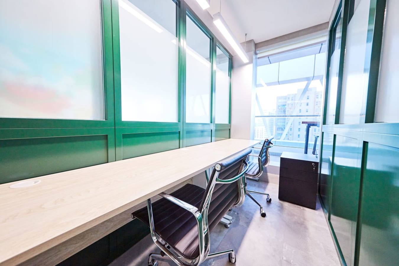 Bright and modern coworking space with sleek chairs, a long desk, and natural light.