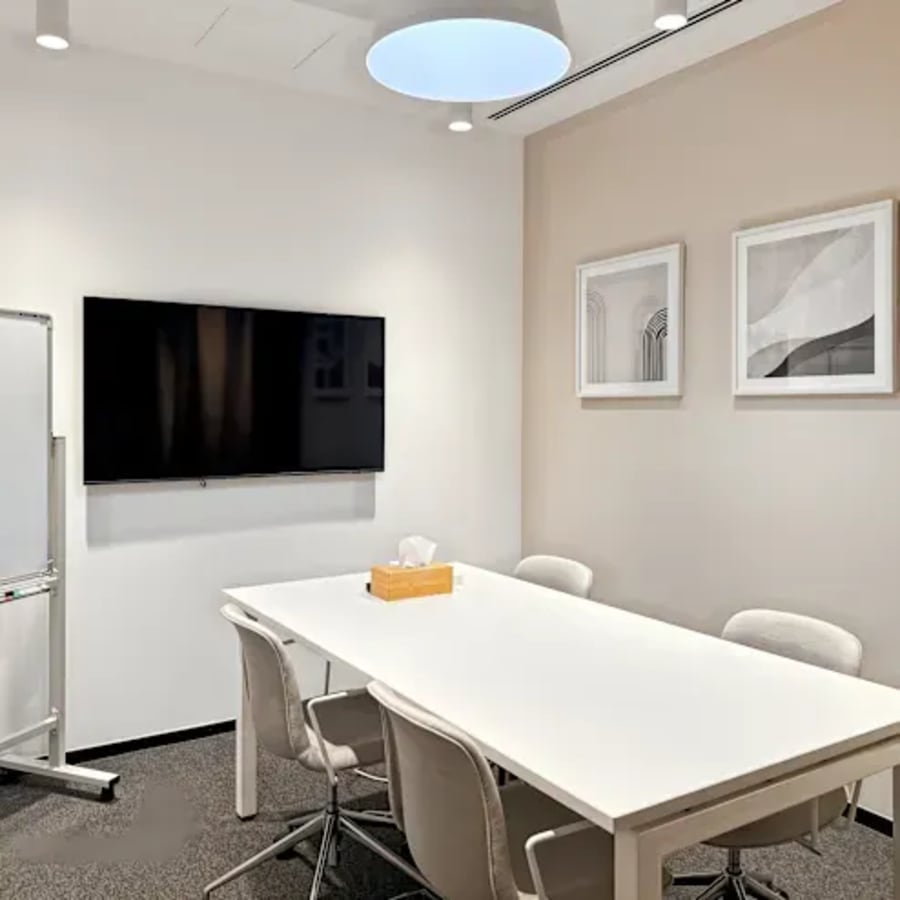 Sleek meeting room with modern decor and presentation tools in a flexible coworking space.