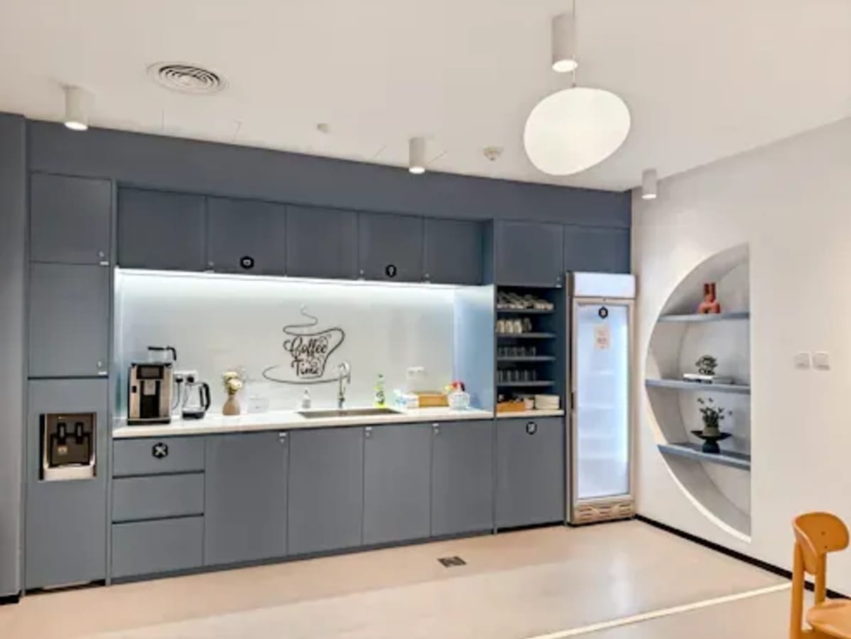 Modern shared kitchen with sleek cabinetry, coffee station, and ample seating in Port Saeed Deira.