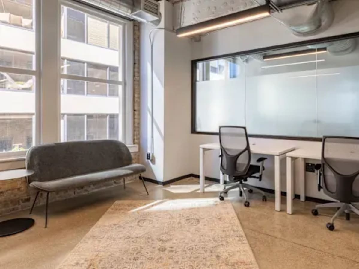 Bright coworking space with modern desks, ergonomic chairs, and cozy seating. Ideal for collaboration.