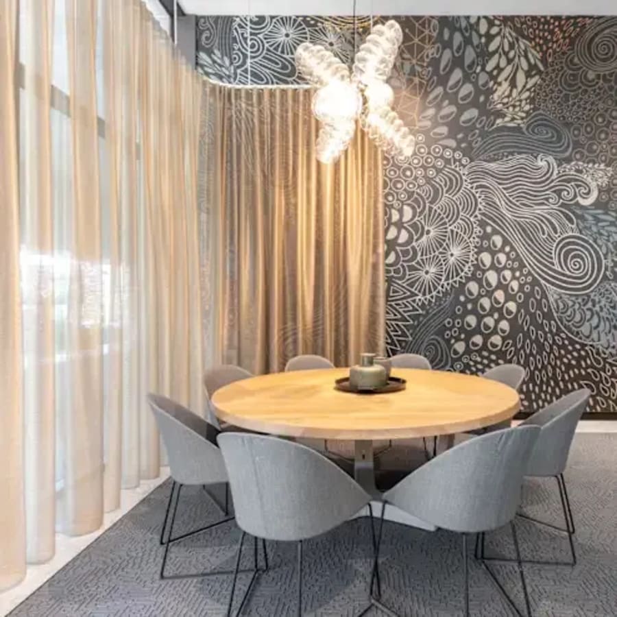 Elegant meeting area with artistic wall design and modern seating. Ideal for collaboration.