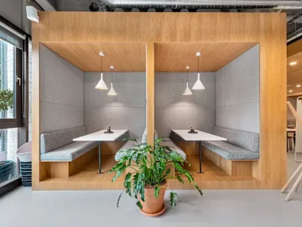 Cozy wooden booths with pendant lighting for intimate meetings. Ideal for collaboration.