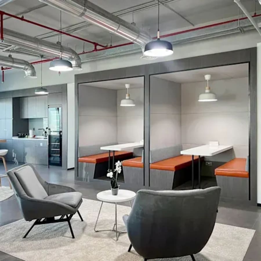 Modern coworking space with cozy seating, stylish booths, and ample lighting in DMCC Free Zone.