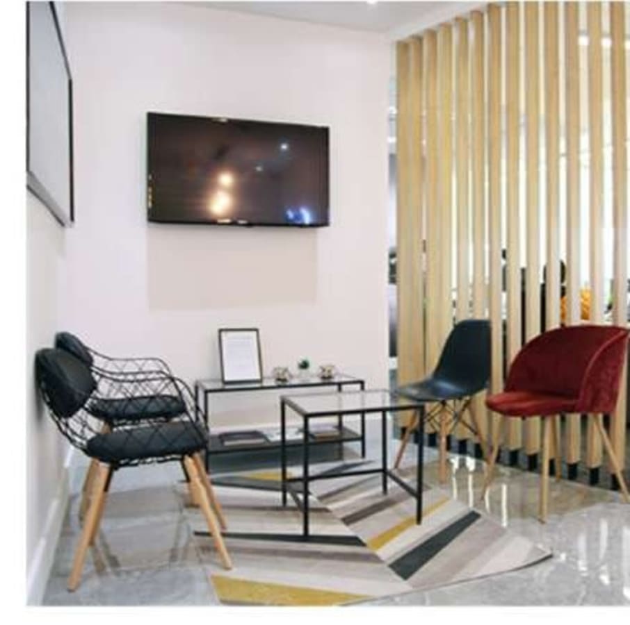Cozy coworking lounge with modern seating and a flat-screen TV. Ideal for collaboration.
