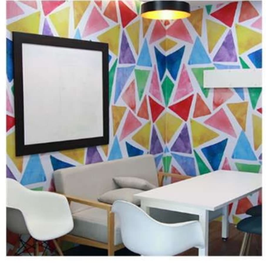 Vibrant coworking space with modern seating and colorful accents. Ideal for creative collaboration.
