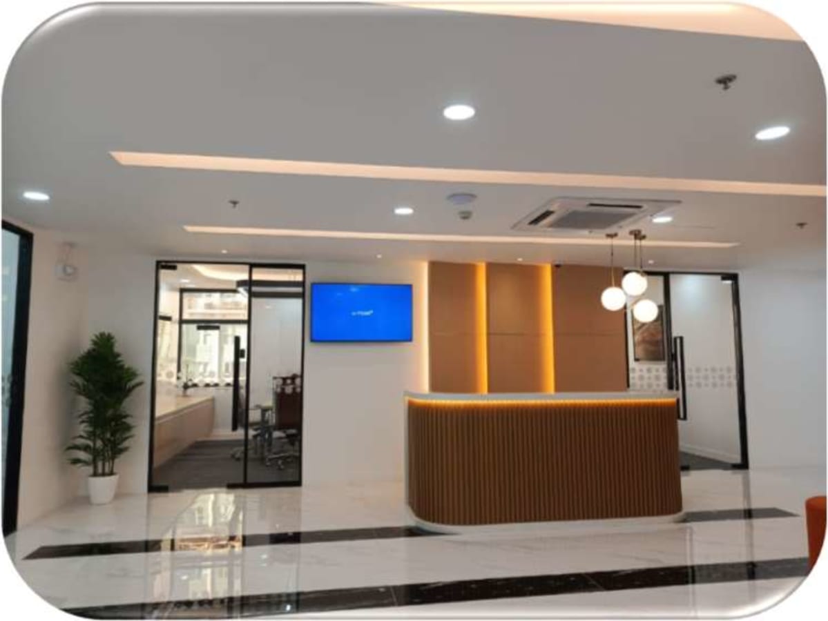 Sleek coworking space with modern reception, ambient lighting, and glass-enclosed meeting rooms.