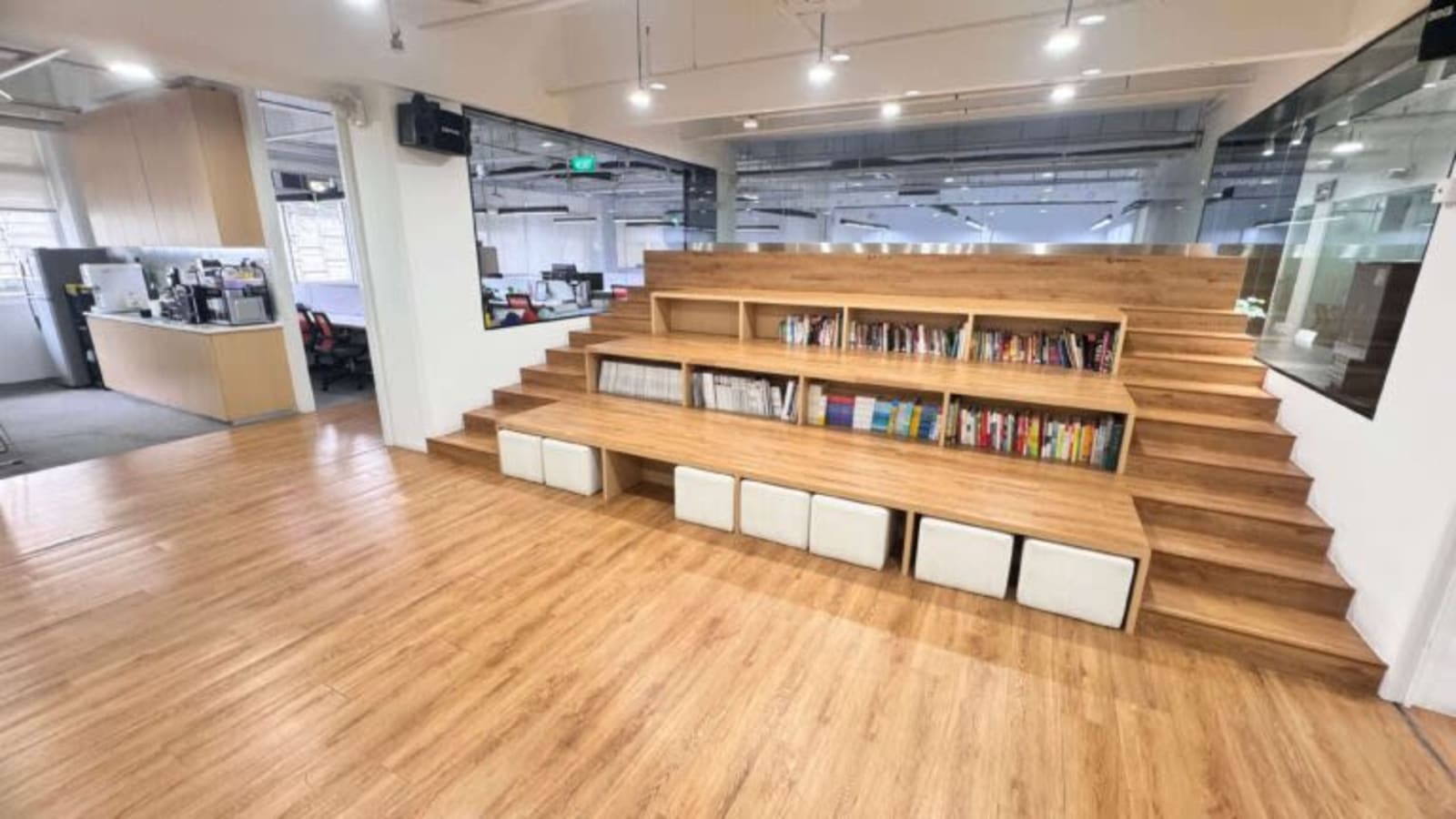 Versatile coworking space with tiered seating, ample natural light, and an inviting atmosphere.