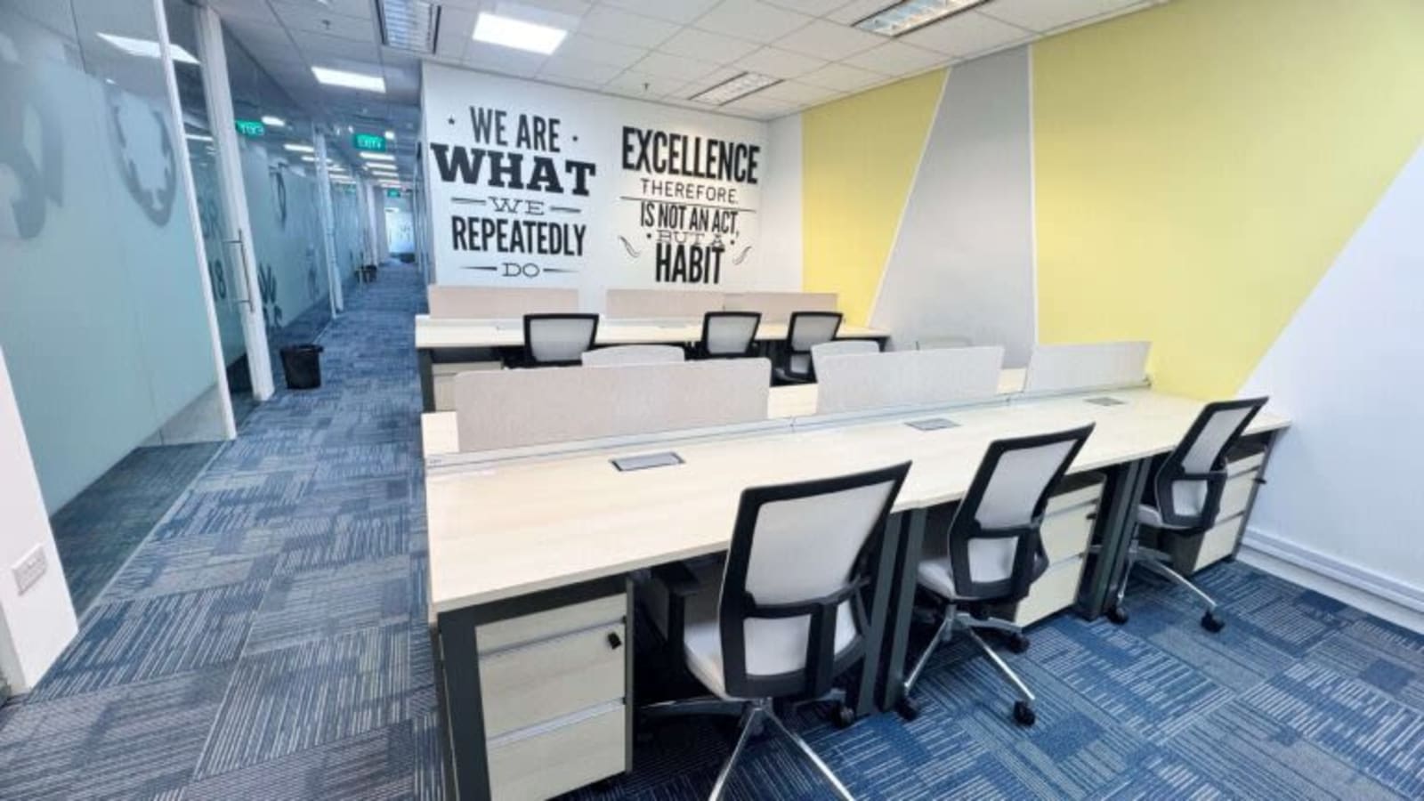 Modern coworking space with ergonomic chairs, inspirational decor, and abundant natural light.