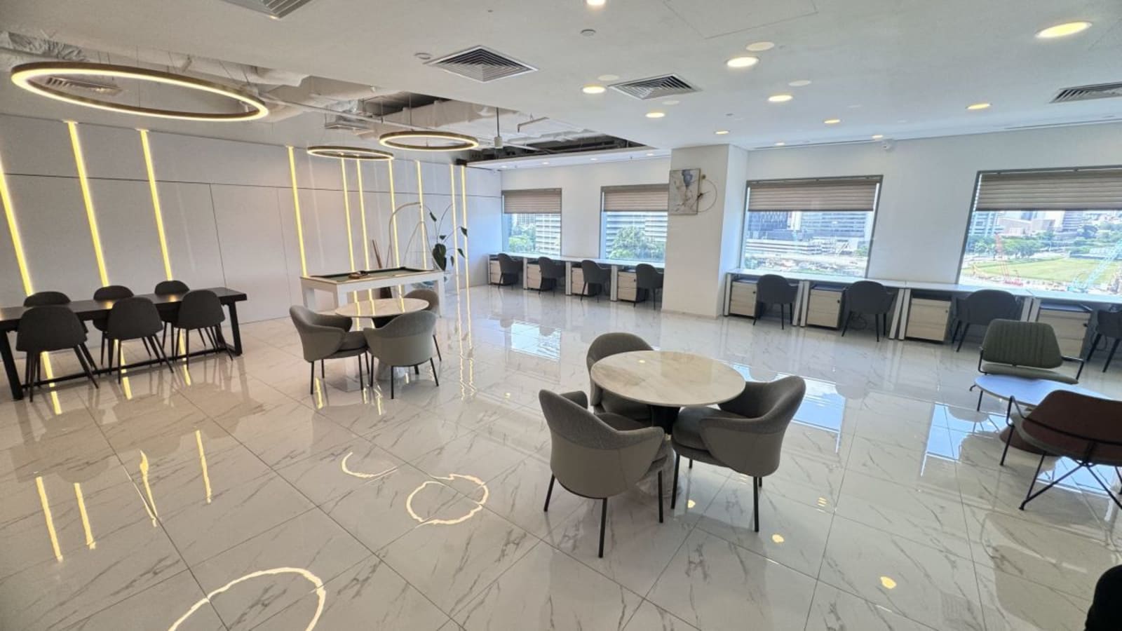 Modern coworking space with sleek furnishings, abundant natural light, and versatile seating.