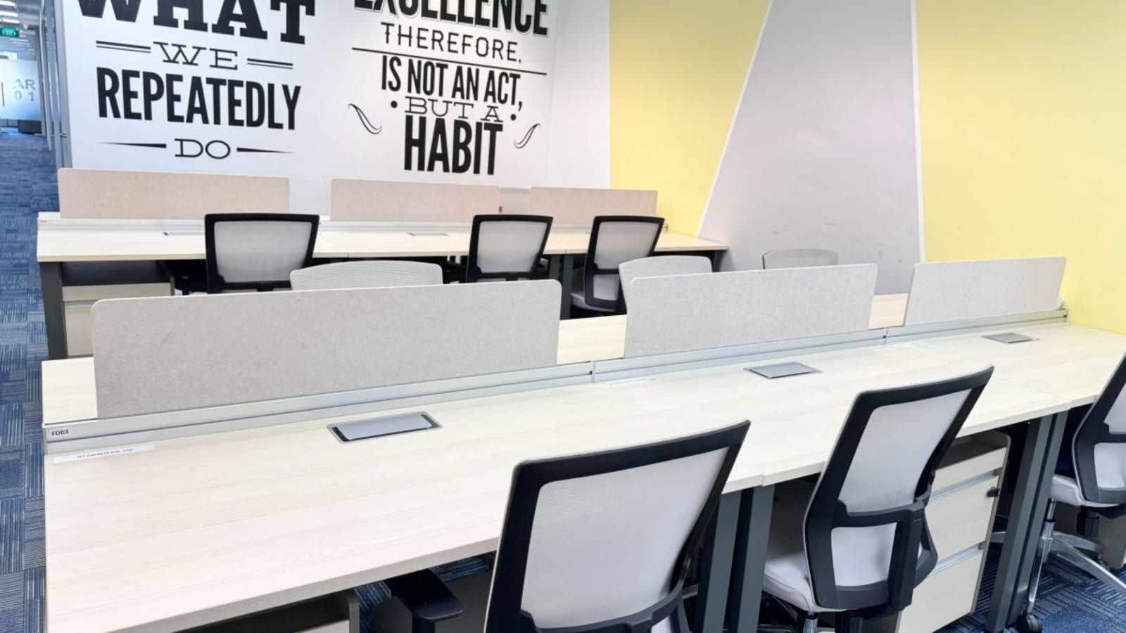 Modern coworking space with ergonomic chairs, ample natural light, and motivational decor.