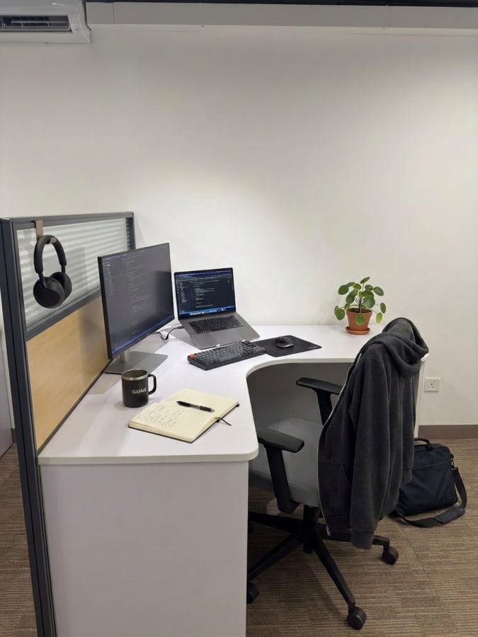 Sleek, modern desk setup with dual monitors and comfortable seating in a coworking space.