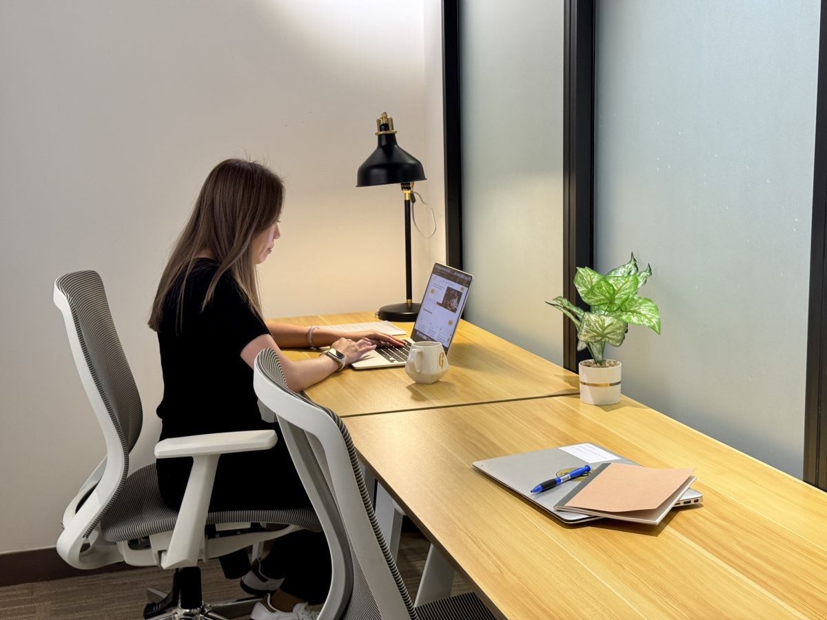 Modern coworking desk with ergonomic chair, ambient lighting, and natural accents.