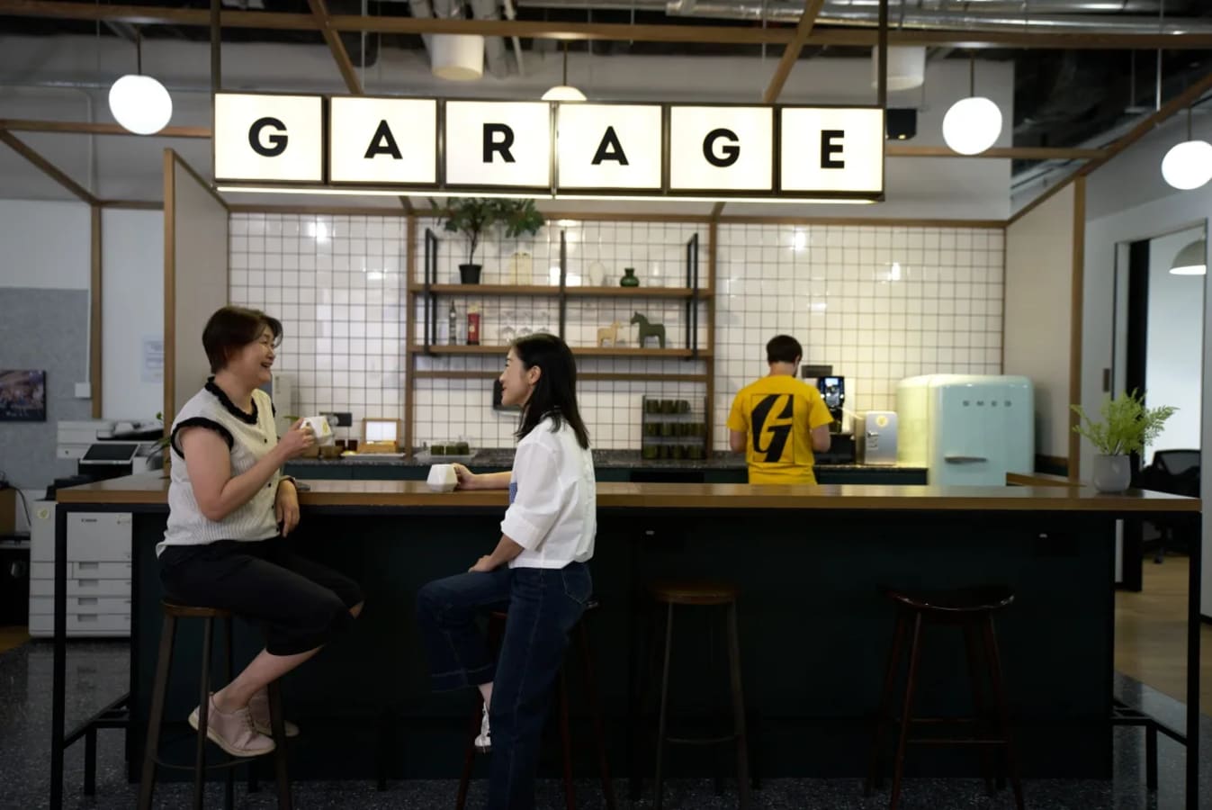 Modern coworking space with a stylish bar area, perfect for networking and collaboration.