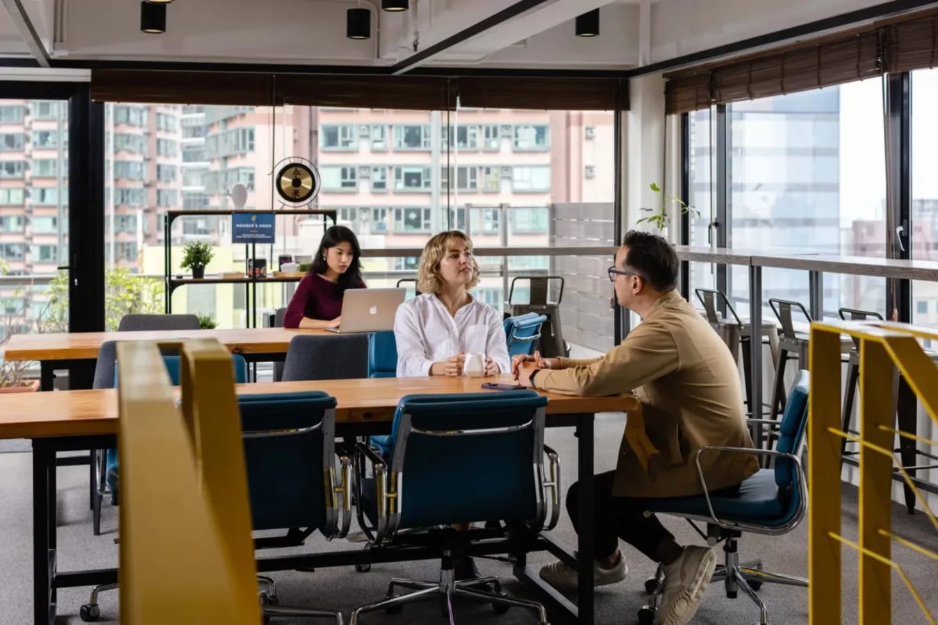 Bright coworking space with modern furniture and city views, perfect for collaboration and focus.
