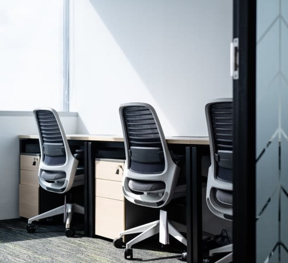 Bright and modern workspace with ergonomic chairs and ample natural light.
