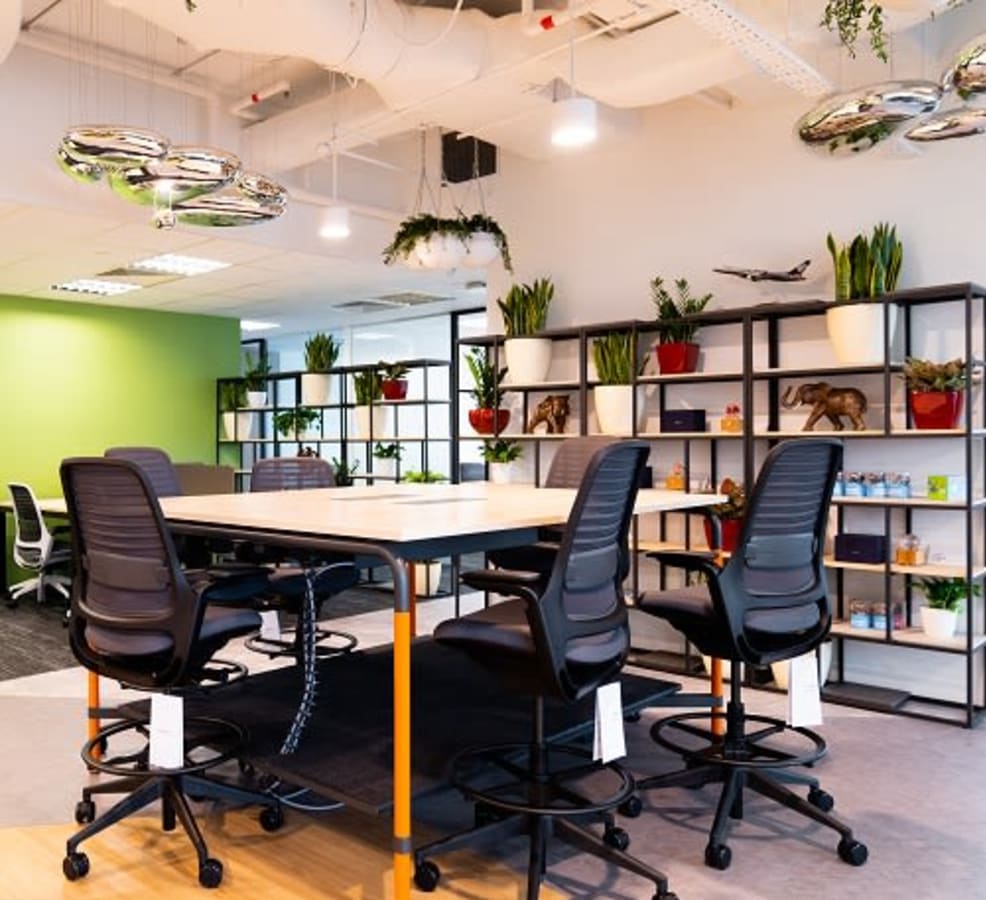 Modern coworking space with vibrant decor, ergonomic seating, and abundant natural lighting.