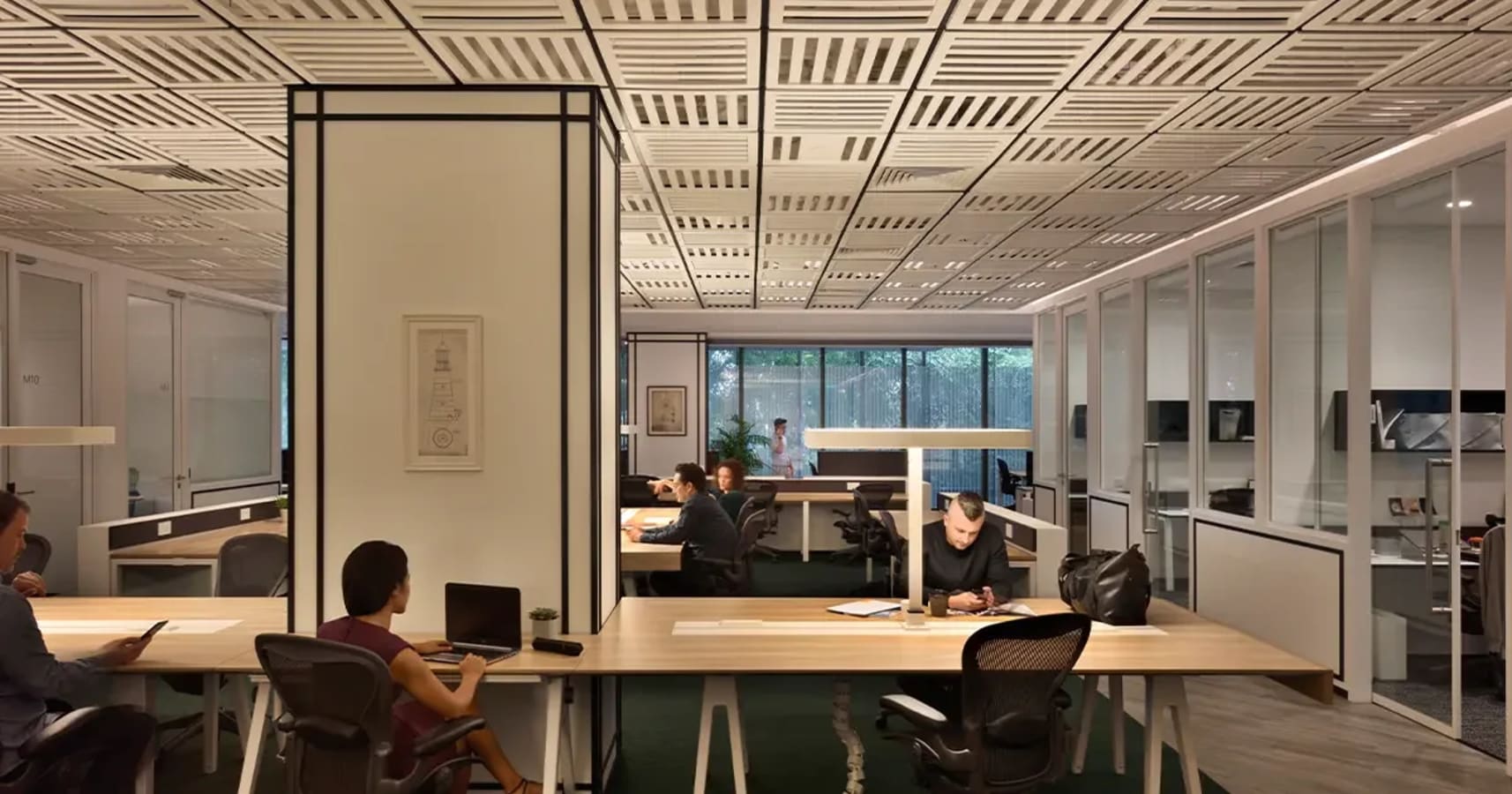 Modern coworking space with open layout, ample natural light, and ergonomic seating.