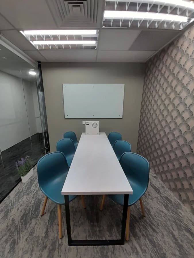 Efficient meeting room with modern seating, whiteboard, and stylish decor in Orchard Road coworking space.