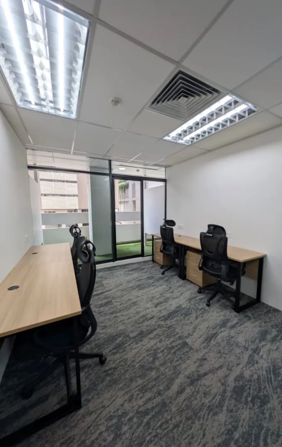 Modern coworking space with natural light, ergonomic chairs, and sleek desks on Orchard Road.
