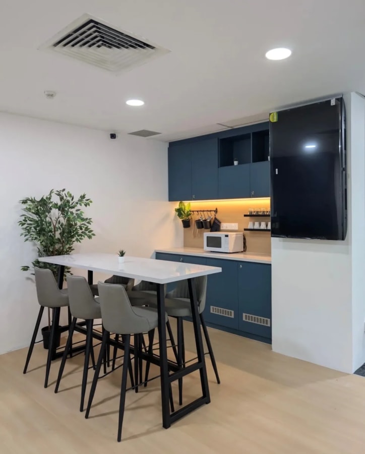 Sleek kitchenette with bar seating, perfect for casual meet-ups in Orchard Road coworking space.