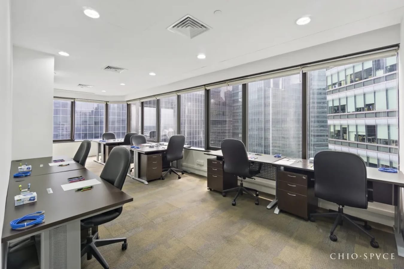 Bright coworking space with city views, modern desks, and ample natural light.