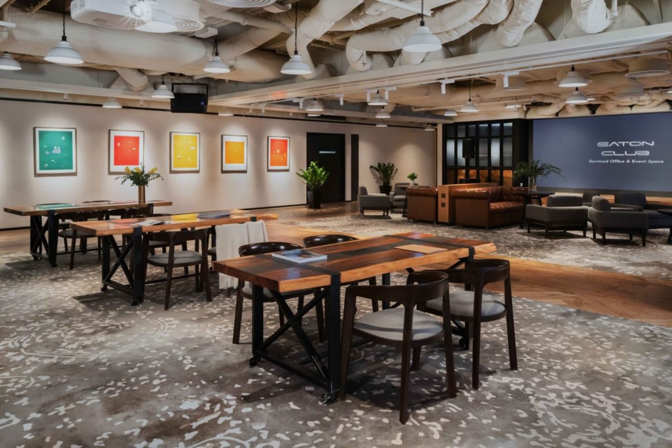 Modern coworking space with open layout, stylish seating, and vibrant artwork. Ideal for collaboration.