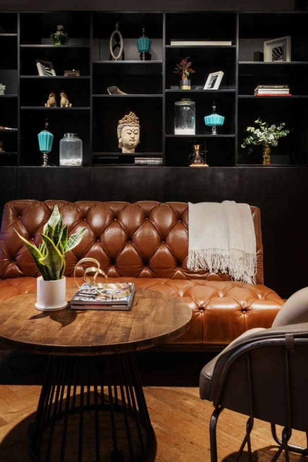 Cozy coworking lounge with a leather sofa, elegant decor, and inviting atmosphere.
