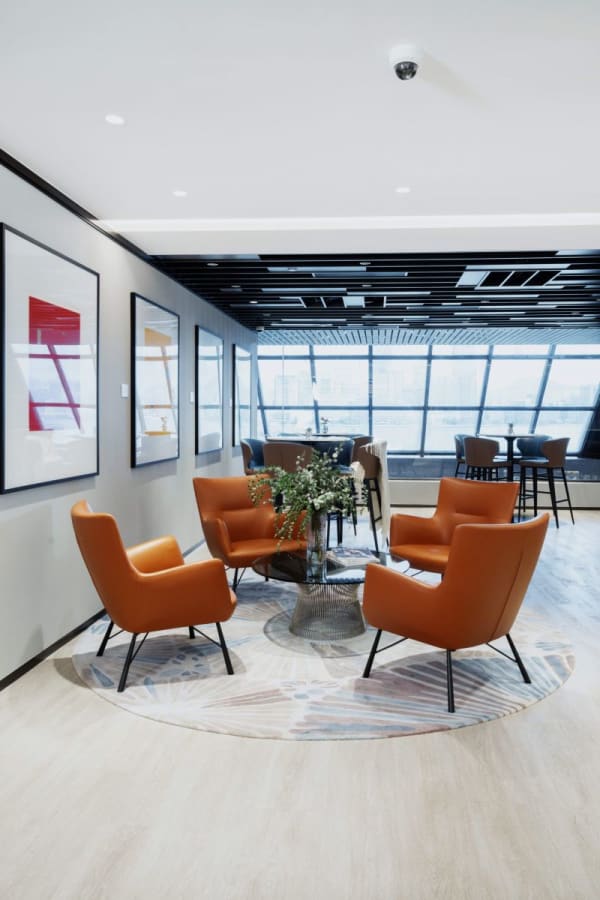 Modern coworking lounge with vibrant seating, wall art, and natural light on Harbour Road.
