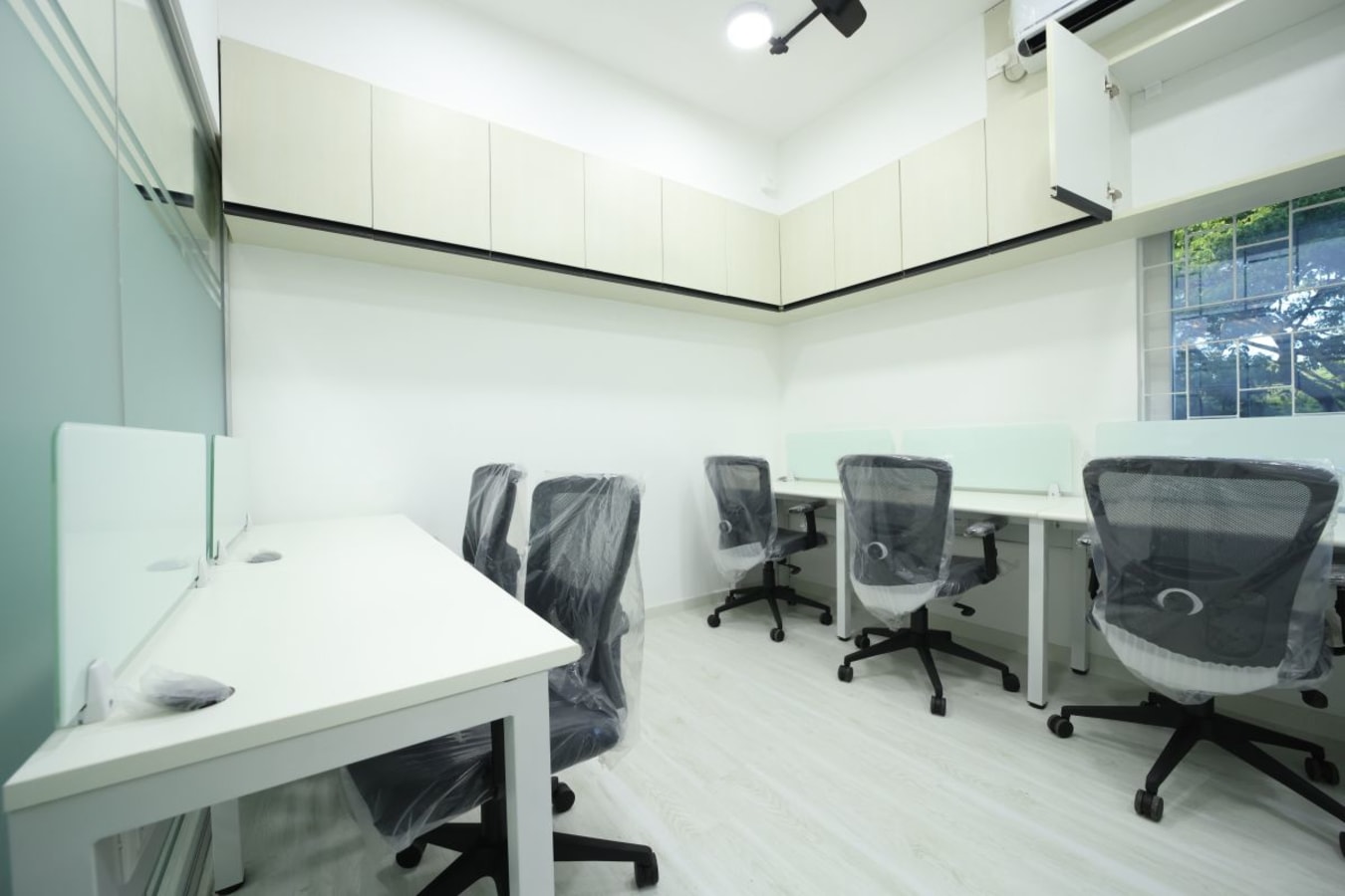 Modern coworking space with ergonomic chairs, ample natural light, and sleek workstations.