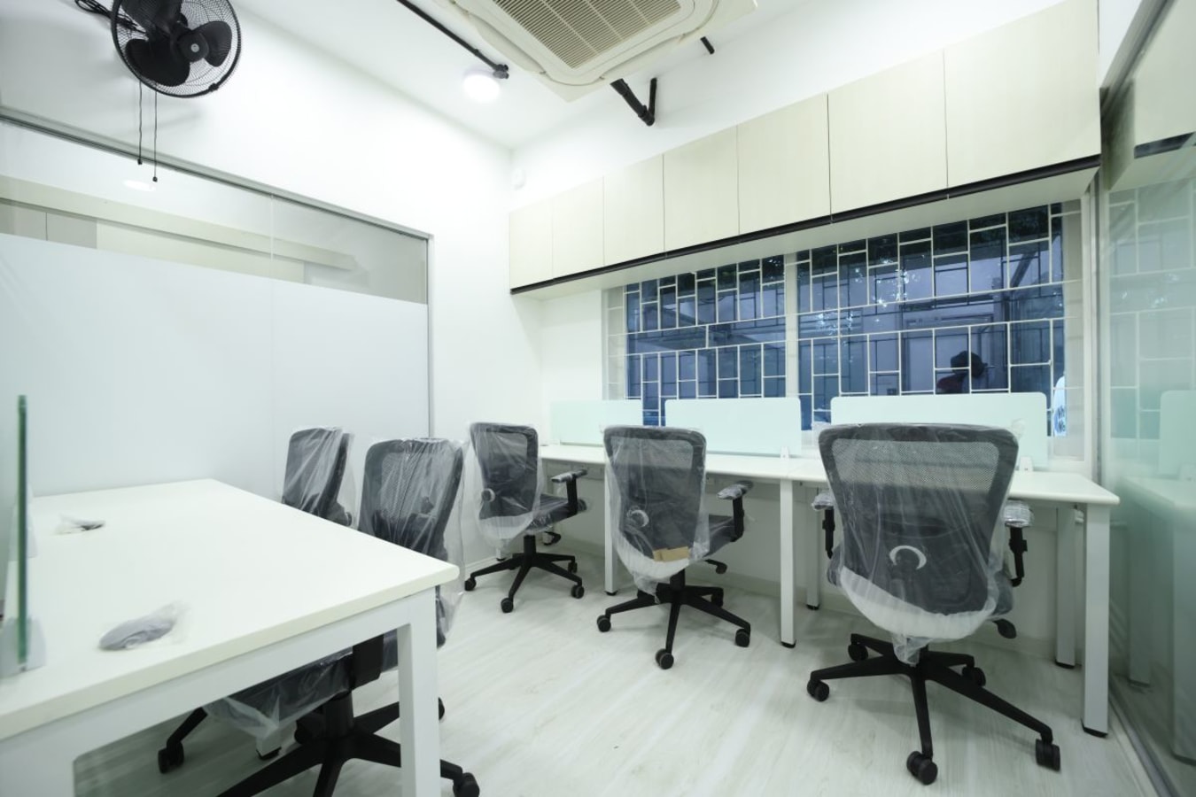 Modern coworking space with ergonomic chairs, clean desks, and ample natural light.