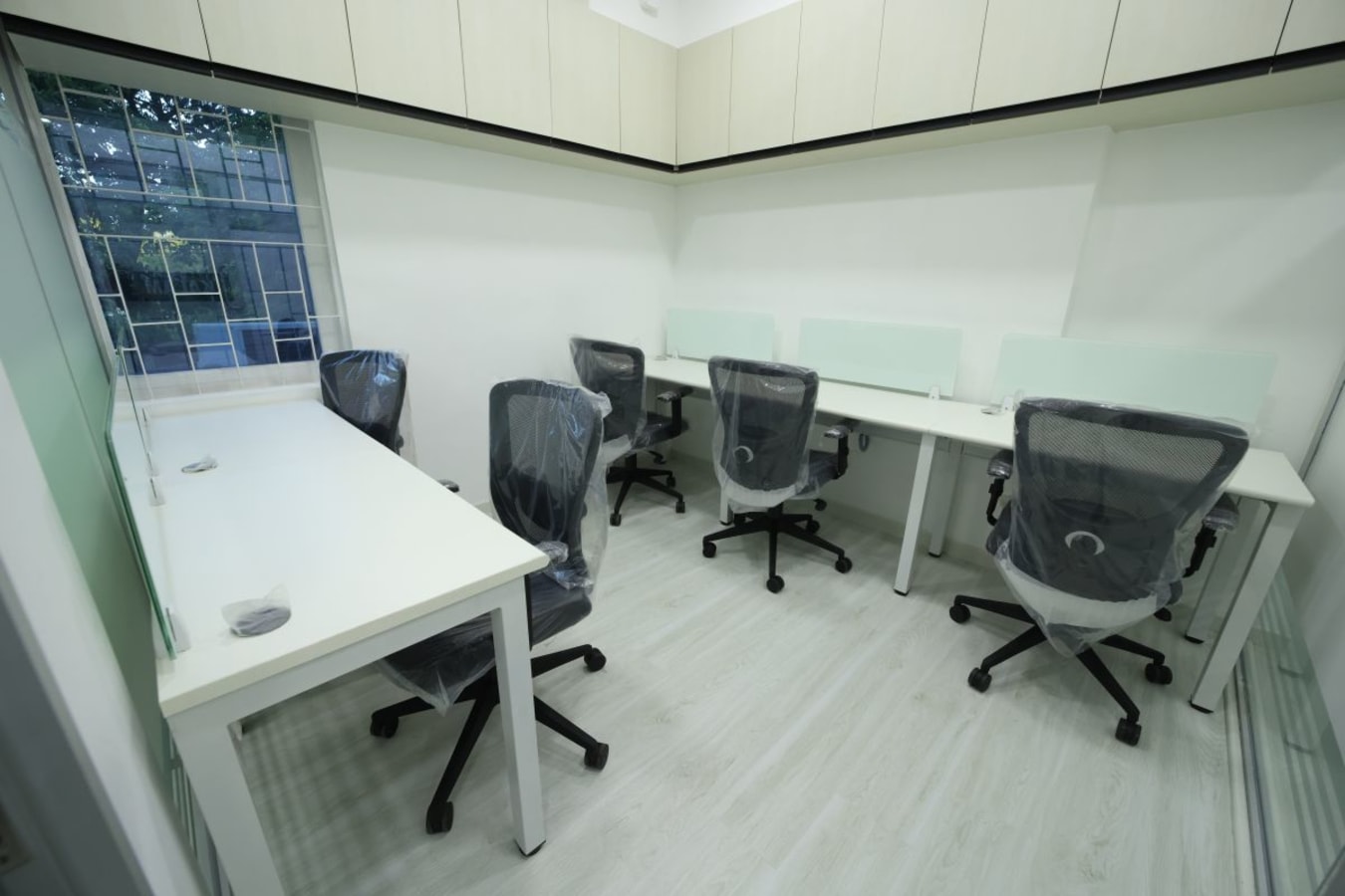 Bright, modern workspace with ergonomic chairs and ample desk space. Ideal for productivity.