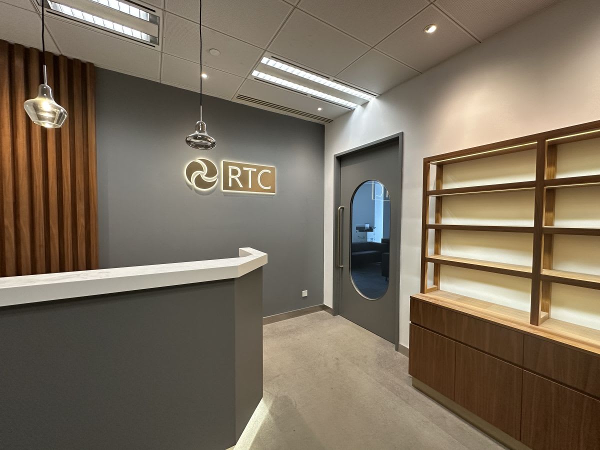 Chic coworking reception with modern lighting and sleek shelving, perfect for professionals.