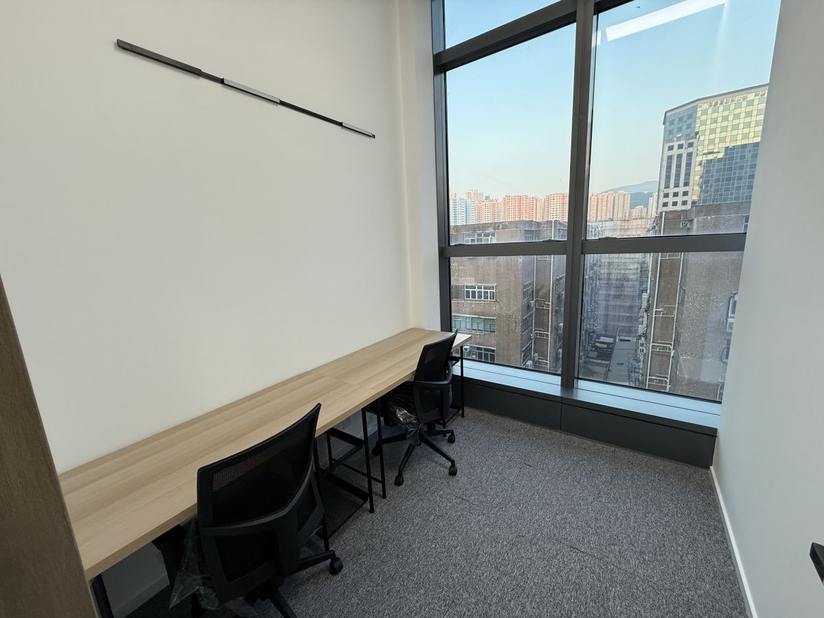 Bright coworking space with large windows and modern desk setup on Wang Chiu Road, Kowloon.