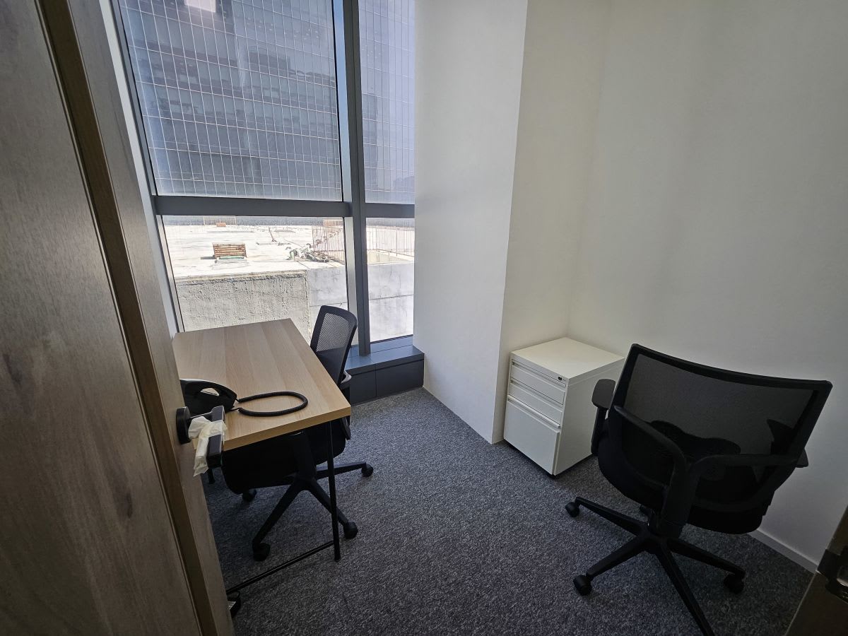Bright, minimalist office with modern desks and ergonomic chairs in Kowloon coworking space.