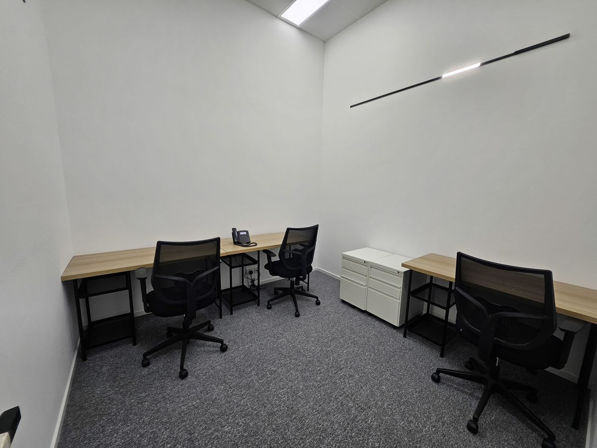 Modern coworking space with ergonomic chairs and ample desk space. Ideal for productivity.