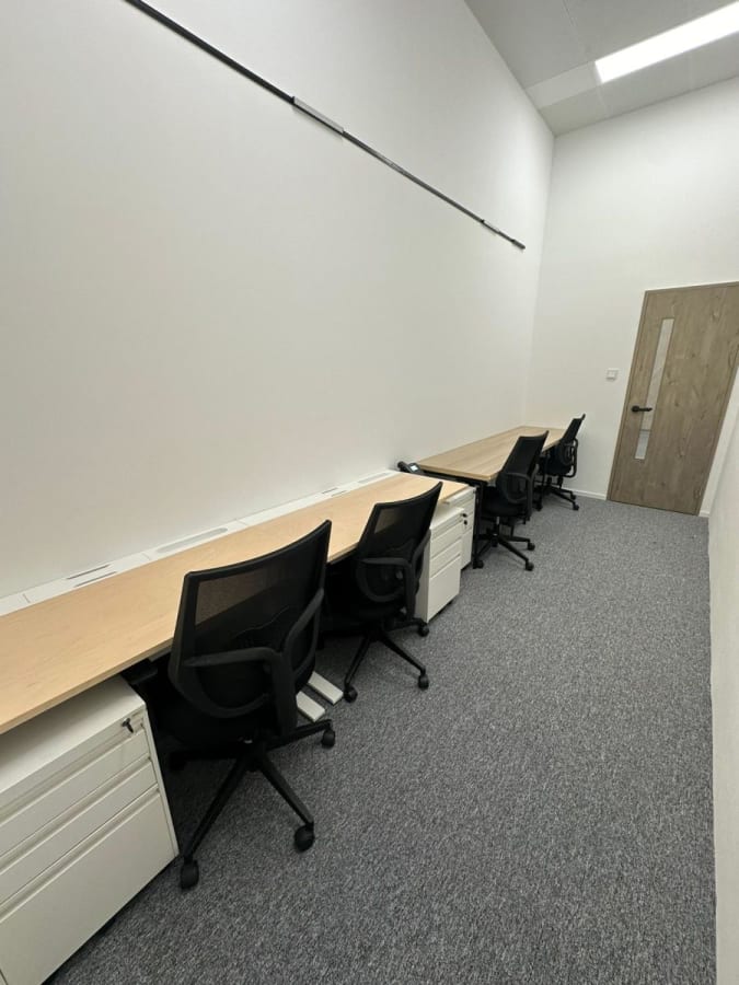 Modern coworking space with sleek desks, ergonomic chairs, and ample lighting. Ideal for productivity.