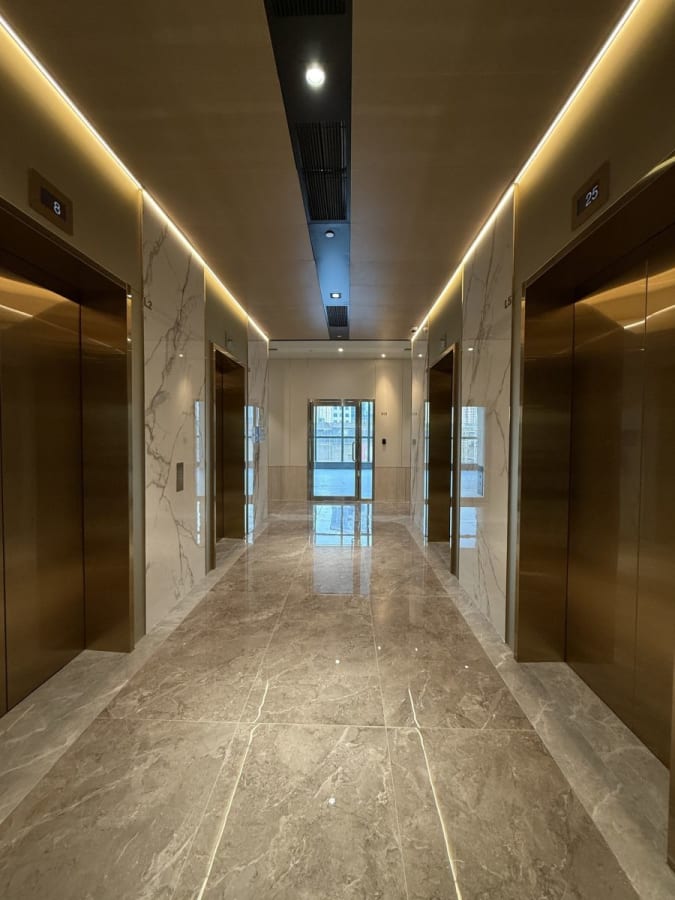 Modern coworking space with elegant marble flooring and sleek elevator access.