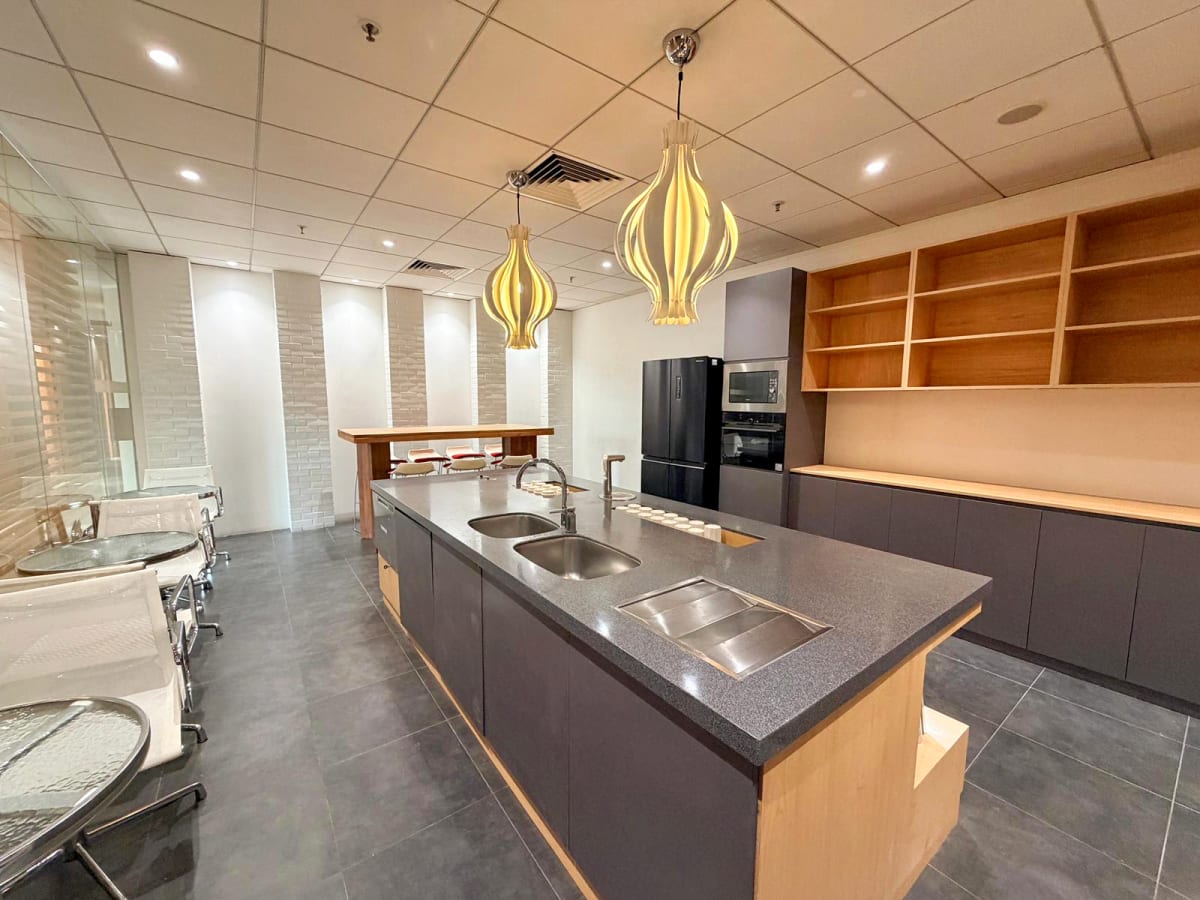 Modern coworking kitchen with sleek countertops and elegant lighting in Kowloon. Ideal for collaboration.