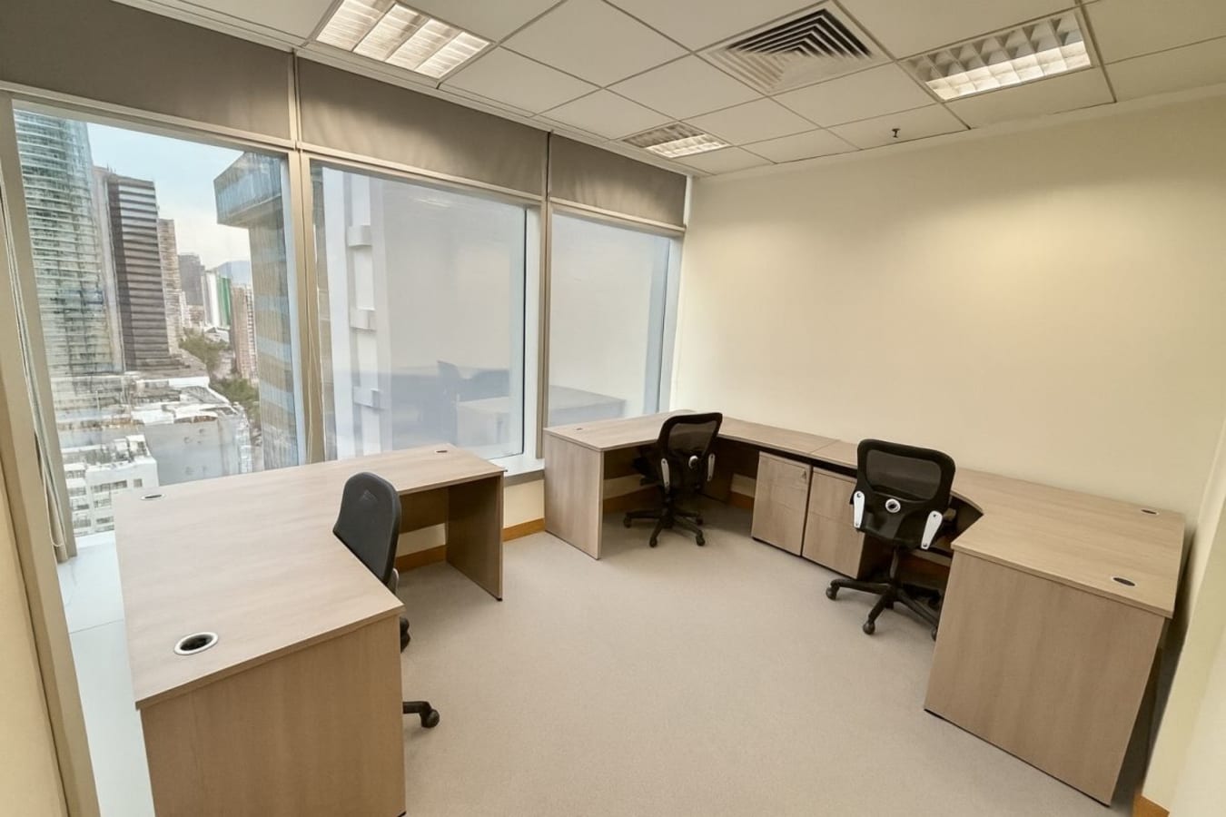 Bright coworking space with ergonomic chairs and panoramic city views. Ideal for productivity.
