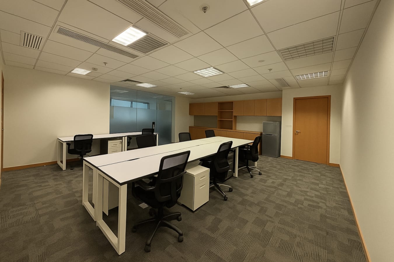Modern coworking space with shared desks, ample storage, and natural lighting in Kwun Tong Road.