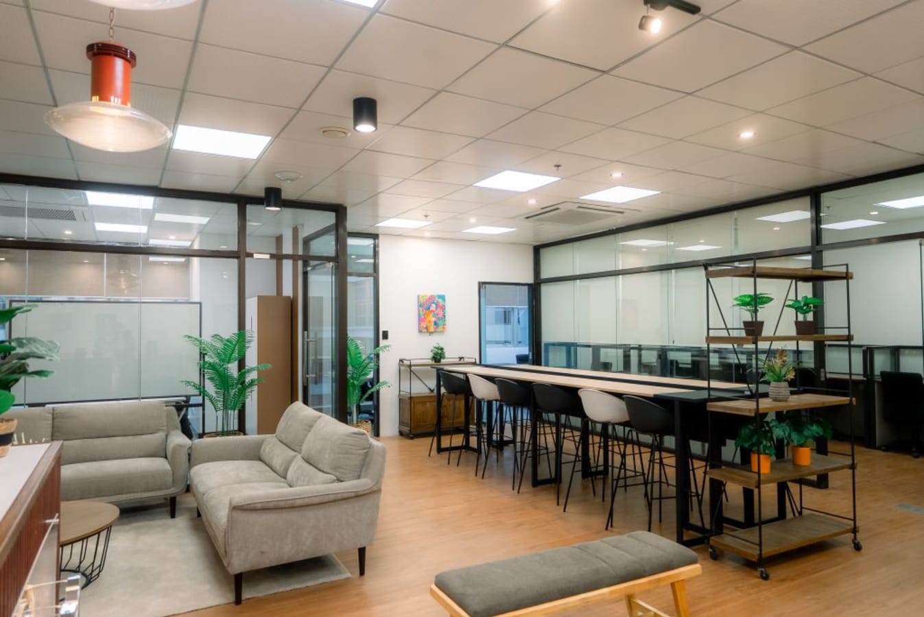 Modern coworking space with comfy seating, ample natural light, and collaborative workstations.