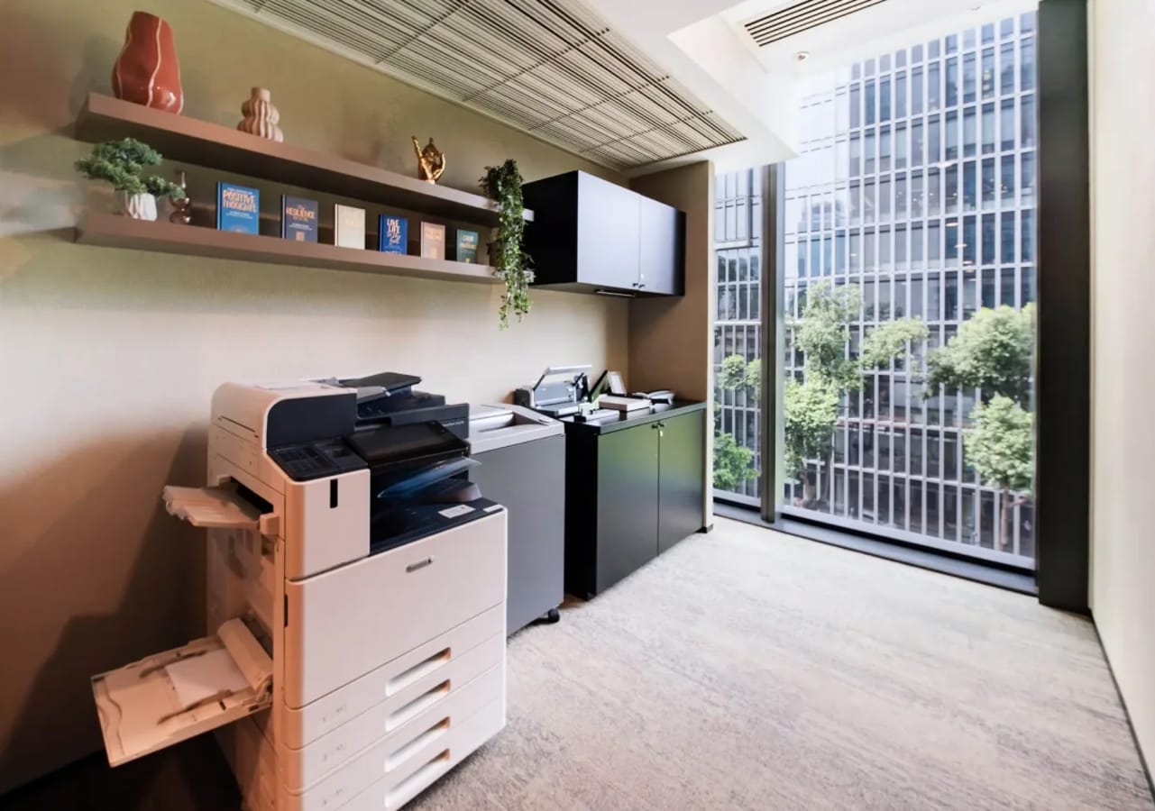 Bright, modern coworking area with copier and storage, featuring striking city views.