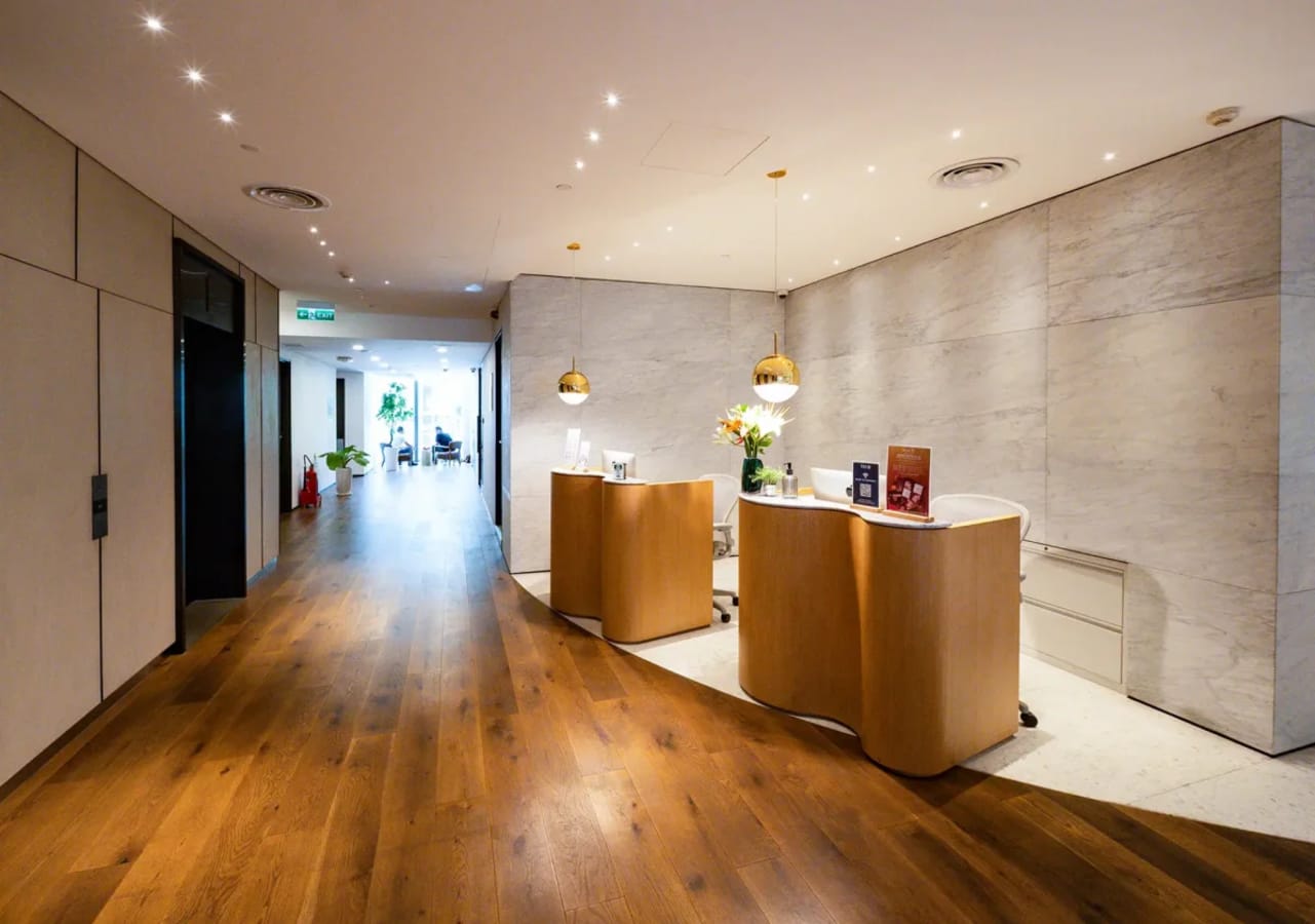 Welcoming reception area with sleek wood floors and modern lighting.