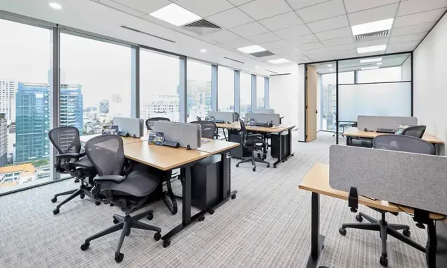 Bright coworking space with city views, ergonomic chairs, and modern desks. Ideal for productivity.