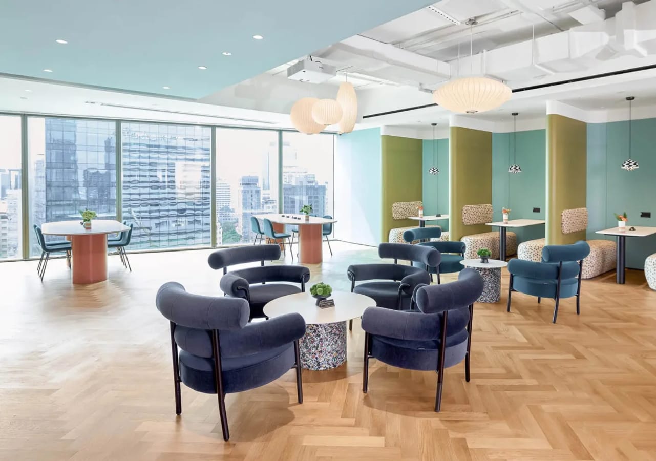 Bright, modern coworking space featuring sleek seating, ample natural light, and city views.