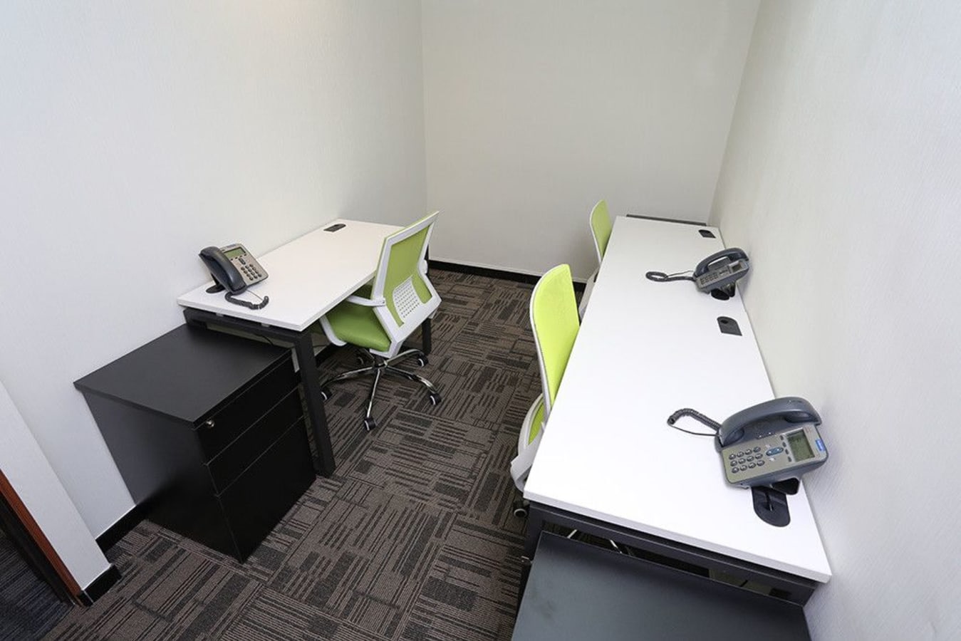 Efficient Kowloon coworking space with modern desks, ergonomic chairs, and phones ready for use.