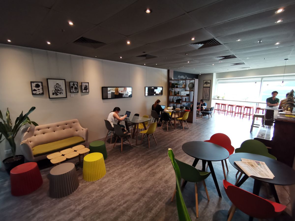Vibrant coworking space with natural light, modern seating, and collaborative work areas.